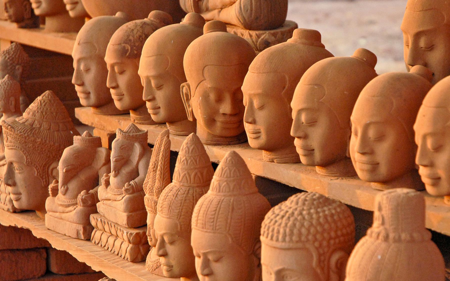 Khmer heritage in clay. Replica heads of ancient deities and Buddhas on display, Cambodia